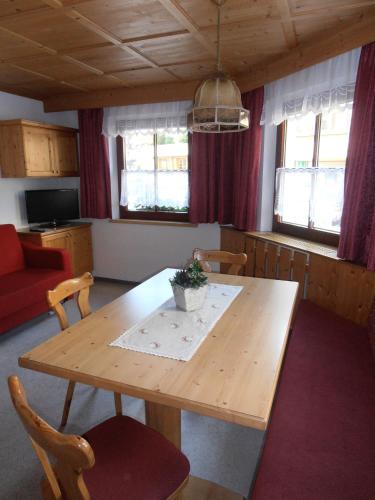 a living room with a wooden table and chairs at Haus Dorfplatz in Galtür