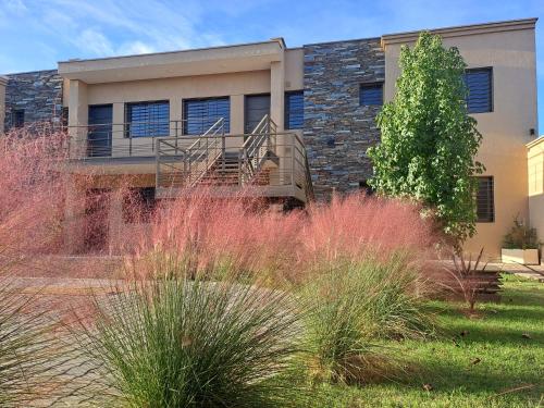 a building with red plants in front of it at UCO APARTS, tu refugio en el corazón de los Andes in Tupungato
