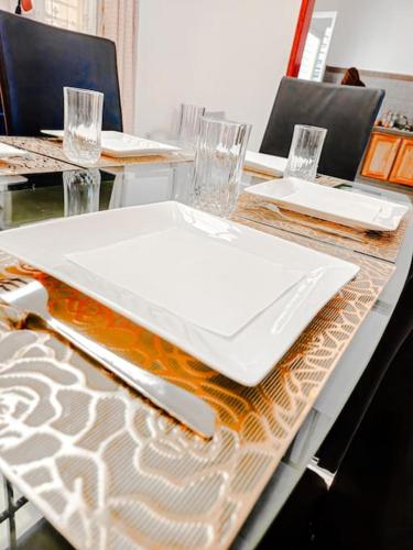 una mesa con un plato blanco encima en La Maison Blanche, en Bafoussam