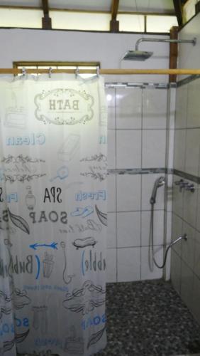 a shower curtain in a bathroom with writing on the wall at casa de los amigos caribena in Cahuita