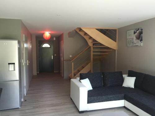 a living room with a couch and a spiral staircase at Petale de Rose, Dunes 3 in Merlimont