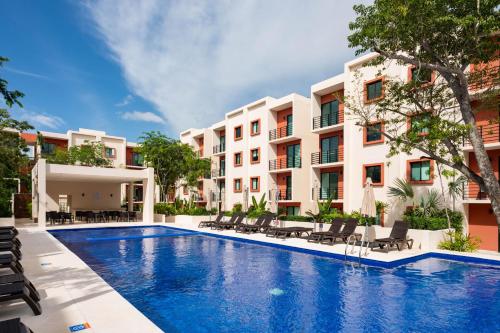 an image of a swimming pool in front of a building at Acogedor apartamento en Ombu Huayacan in Cancún