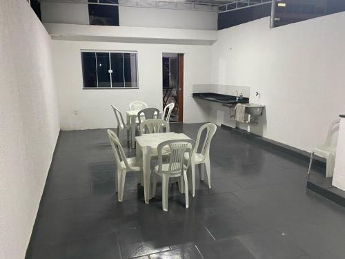 una sala da pranzo con tavolo e sedie bianche di Suite 3, Casa Amarela, Terceiro Andar a Nova Iguaçu