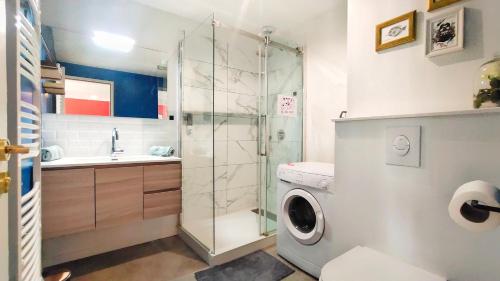 uma casa de banho com um chuveiro e uma máquina de lavar roupa em Votre Escale - Magellan Cinéma em Niort