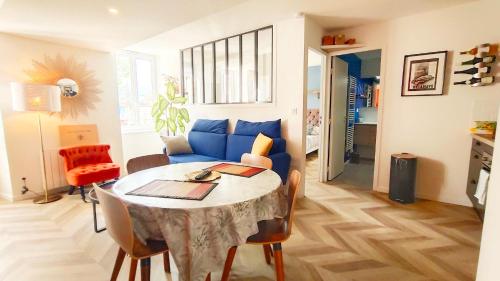 - un salon avec une table et un canapé bleu dans l'établissement Votre Escale - Magellan Cinéma, à Niort