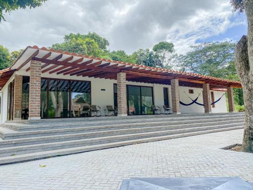 a house with a large wooden deck with a patio at CABAÑA TAYRONACA in Calabazo