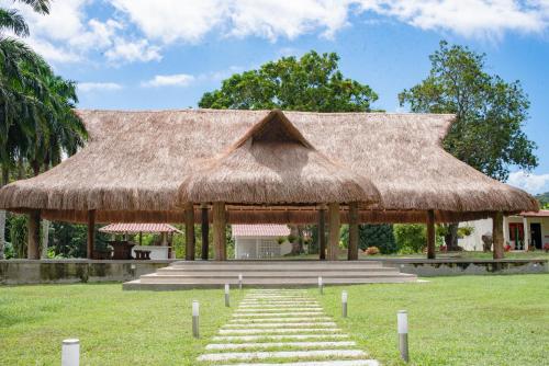 a large hut with a thatched roof and stairs at CABAÑA TAYRONACA in Calabazo