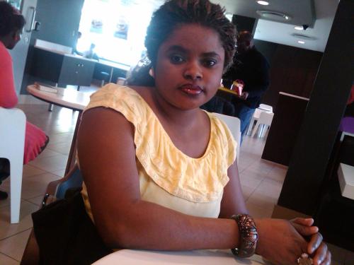 a woman sitting at a table in a restaurant at GOLBRITAK LODGE in Ibadan