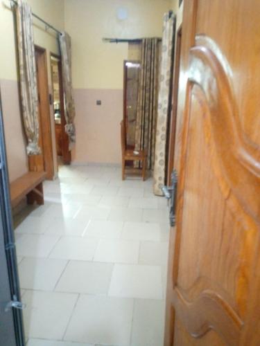 a hallway with a door and a floor with white tiles at ROYAL HOUSE INTERNATIONAL in Porto-Novo