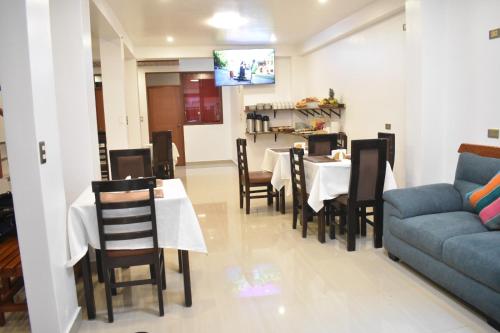 a dining room with a table and chairs and a couch at Inti Pacha Palace Machupicchu in Machu Picchu