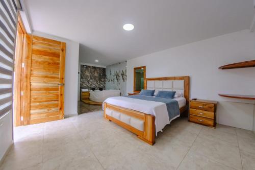 a bedroom with a large bed and a bathroom at HOTEL LLANO CAMPESTRE in La Concepción