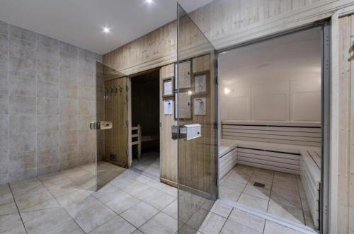 une salle de bain avec douche et porte vitrée dans l'établissement Arc 1950 - Appt 2CH - 6 pers - Rés 5* luxe - Piscine, sauna, hamman, jacuzzi - Classé 5 cristaux Paradiski, à Arc 1950
