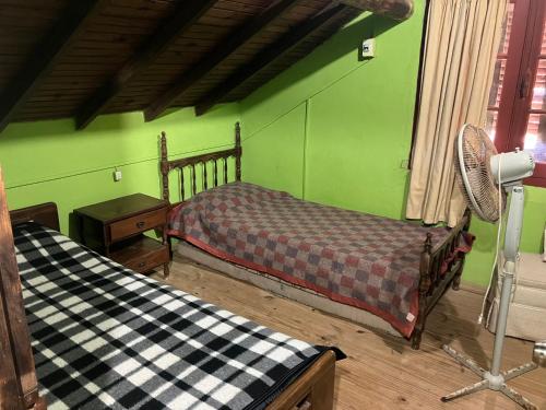 1 dormitorio con 2 camas y pared verde en Lobos, en Aguas Dulces