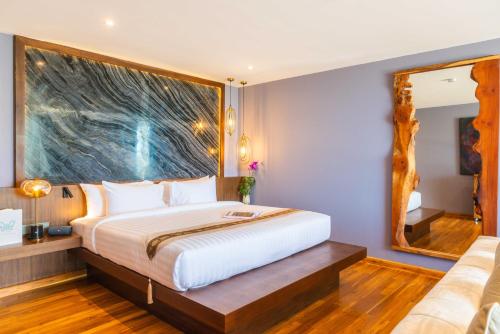 una camera con un grande letto e uno specchio di IDA B Domain a Nathon Bay