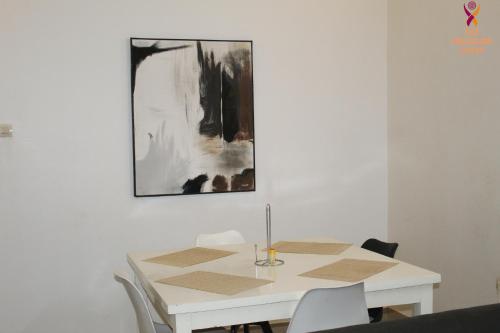 uma mesa branca com cadeiras e um quadro na parede em Two Bedroom Villa at Ouagadougou em Ouagadougou