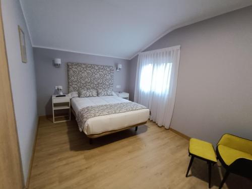 sypialnia z łóżkiem, stołem i krzesłami w obiekcie Casa fredi w mieście Cangas de Onís
