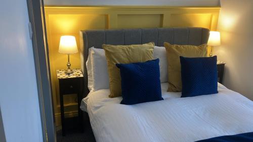 a bedroom with a large bed with blue pillows at Lisheen Lodge in Galway