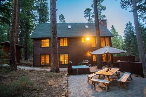 a log cabin with a picnic table and an umbrella at The Tallac Lodge Hot Tub Walk 2 Beach in Carnelian Bay