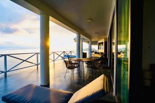 a balcony with a table and chairs on a building at Villa Club Tropicana Carana with infinity pool in Machabee