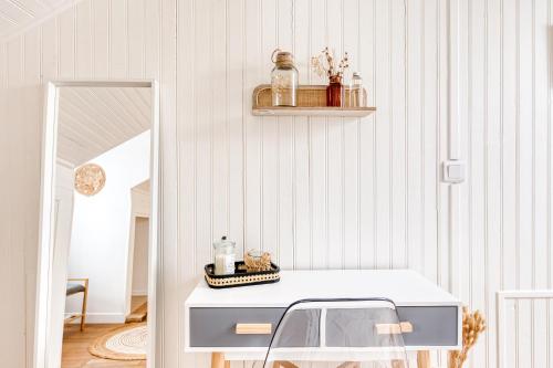 a room with a white table and a chair at Maison de ville triplex proche CDG in Sevran