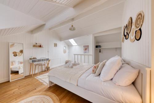1 dormitorio con 1 cama grande con almohadas blancas en Maison de ville triplex cosy, en Sevran