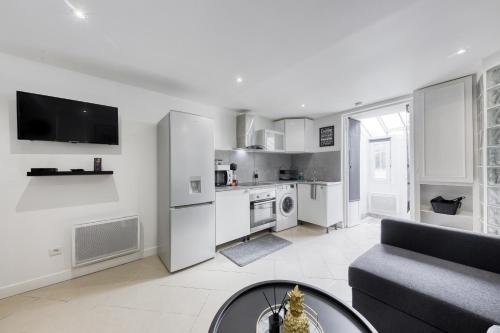 un salon avec un canapé et une cuisine dans l'établissement Maison de ville triplex proche CDG, à Sevran