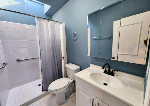 a bathroom with a toilet and a sink and a shower at Montrose Oasis Pool & Hot Tub in Houston
