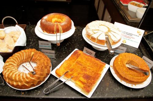 a display of different types of cakes and pies at San Rafael Comfort Class Hotel in Foz do Iguaçu