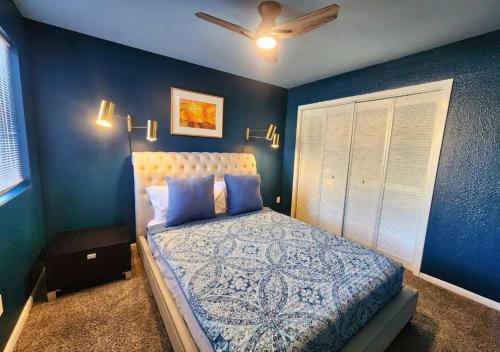 a bedroom with a bed with blue walls and a ceiling at Montrose Oasis Pool & Hot Tub in Houston