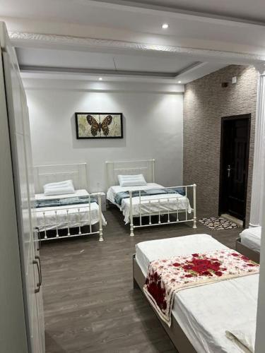 a room with three beds and a butterfly picture on the wall at Family Apartment 1 kilometers Near Masjid Nabawi SAW in Al ‘Awālī