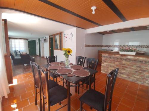 een eetkamer met een tafel en stoelen en een open haard bij ALMANIK VIAJERO in Villa de Leyva