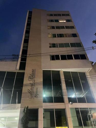 um edifício alto com muitas janelas em Alugo 1 Suite 210 no Mont Blanc em Nova Iguaçu