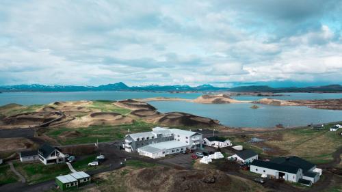 eine Luftansicht eines Hauses auf einem Hügel neben einem See in der Unterkunft Sel - Hótel Mývatn in Mývatn