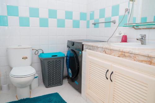 a bathroom with a washing machine next to a sink at Ocean Breeze Malabata Appartement in Tangier