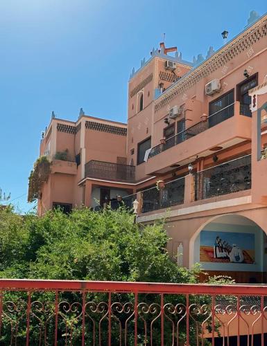 a large pink building with a red balcony at Kasbah La Famille Berbère in Boumalne