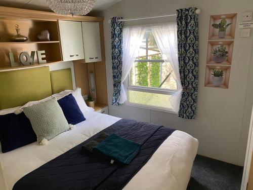 a bedroom with a large bed and a window at All Weather Hot Tub & Cosy Cabin in Northumberland in Morpeth