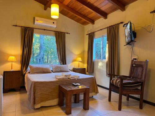 1 dormitorio con 1 cama, 1 silla y ventanas en Quebrada Mansa en Nono