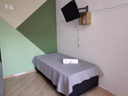 ein kleines Bett in einem Zimmer mit in der Unterkunft Edícula c/ wifi e banheiro externo em Capão Bonito in Capão Bonito