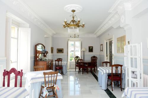 a dining room with tables and chairs and a chandelier at Hotel Rural El Solar del Mazo in Rada