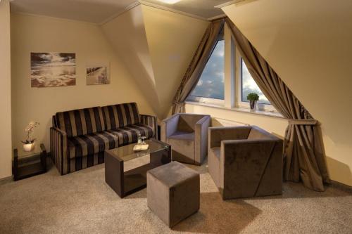 a living room with a couch and a window at Hotel Am Markt Nordenham in Nordenham