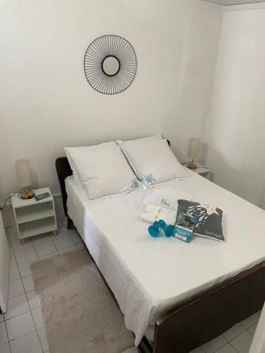 a bedroom with a bed with white sheets and a mirror at LAKAY SONSON in Les Anses-dʼArlets