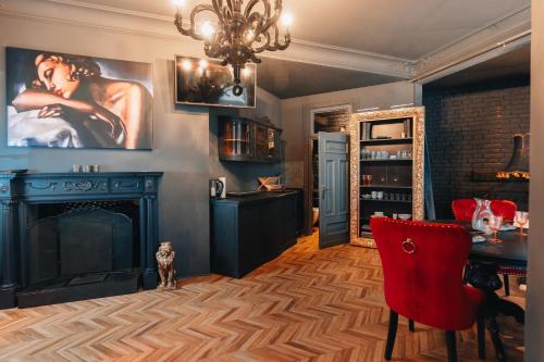 a living room with a fireplace and a red chair at EASY RENT Apartments - Litewski Styl, Centrum 24h Check-in in Lublin