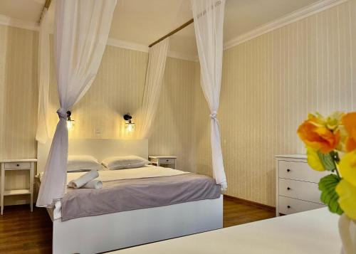 um quarto com uma cama de dossel branca em Cozy Hideout - Condo Hotel em Timisoara