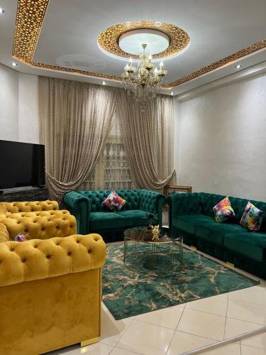 uma sala de estar com sofás verdes e um lustre em A room in Guéliz only for ladies em Marrakech