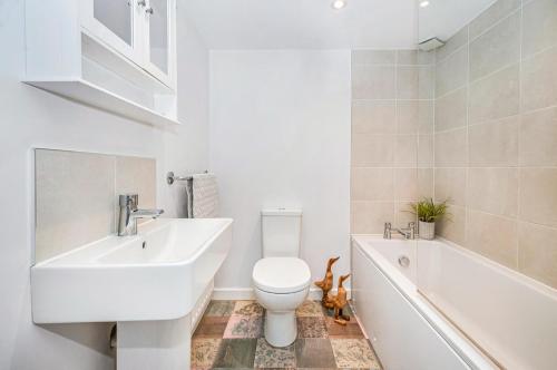 y baño con lavabo, aseo y bañera. en Puddle Duck Cottage en Cranswick