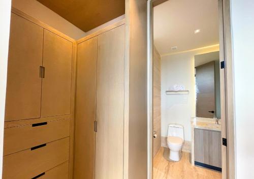 baño con armarios de madera y aseo en Brand new condo with Rooftop pool en Cozumel