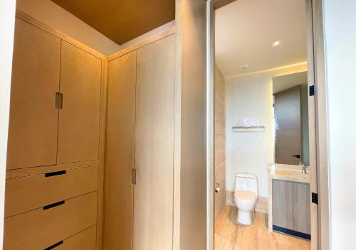 bagno con armadi in legno e servizi igienici. di Brand New Condo with Rooftop Pool a Cozumel