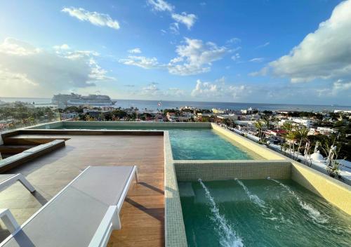 a swimming pool on the roof of a building at Brand New Condo with Rooftop Pool in Cozumel