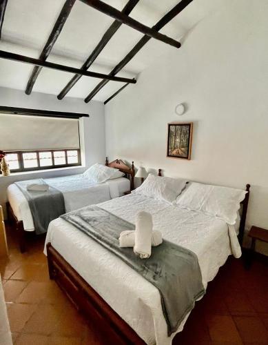 een slaapkamer met 2 bedden en handdoeken bij Hotel-Apartahotel Boutique Piedra & Luna in Villa de Leyva