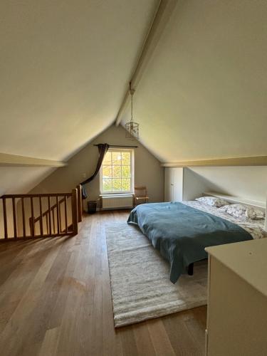 ein Schlafzimmer mit einem Bett und einem großen Fenster in der Unterkunft Duplex Rosières - 12’ de Bruxelles in Rixensart